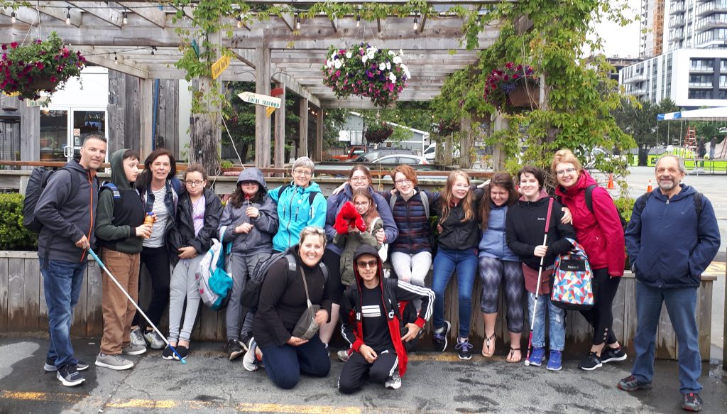 Photo de groupe de 16 participants au camp et fleurs à l'arrière plan