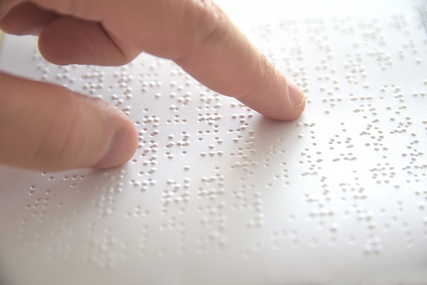 Photo d'un index lisant un texte Braille